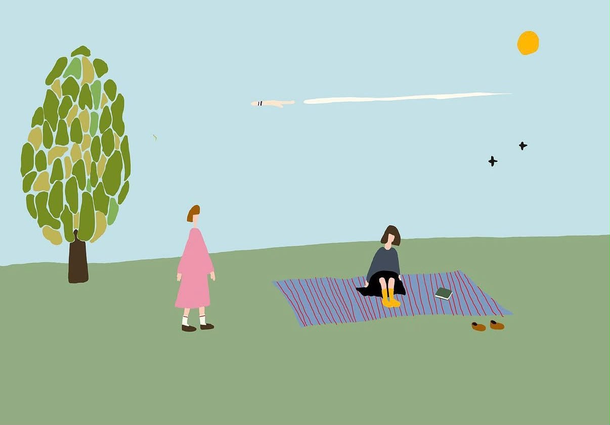 Two people resting in a green field beneath a pale blue sky